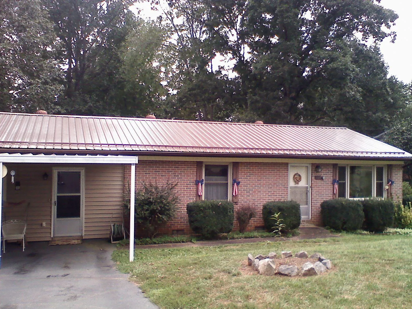 Bronze metal roof and carport on a brick ranch home — Roof Repair work by our crew in Hurley
